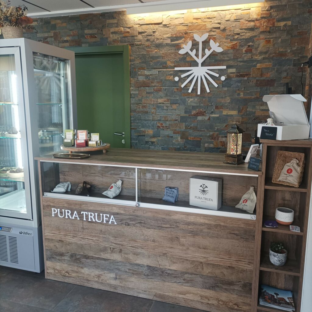 Interior de la tienda Pura Trufa con mostrador de atención al cliente y logo corporativo al fondo.
